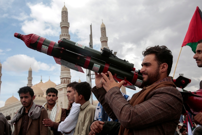 胡塞武装的支持者手持模拟的火箭发射器。 美联社